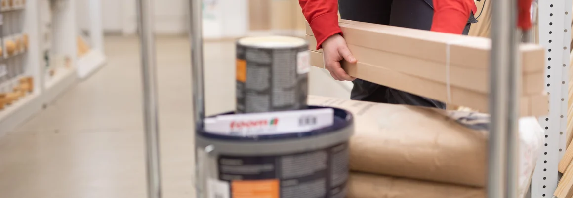 Person legt Holz auf einen Wagen.